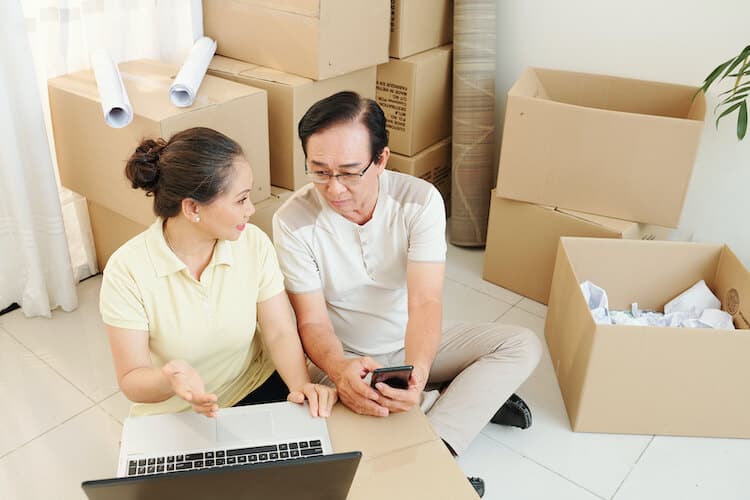 Senior couple researching a place to donate household items during their move.