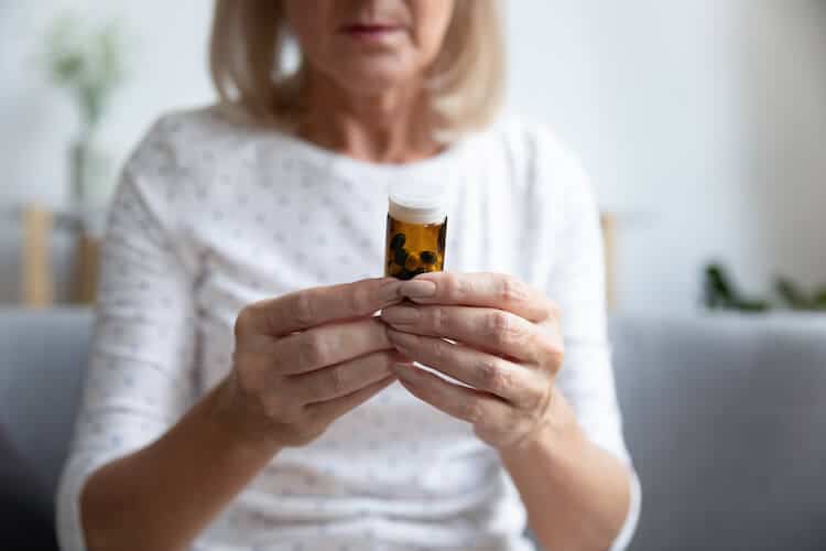 Senior woman reading a medication label.