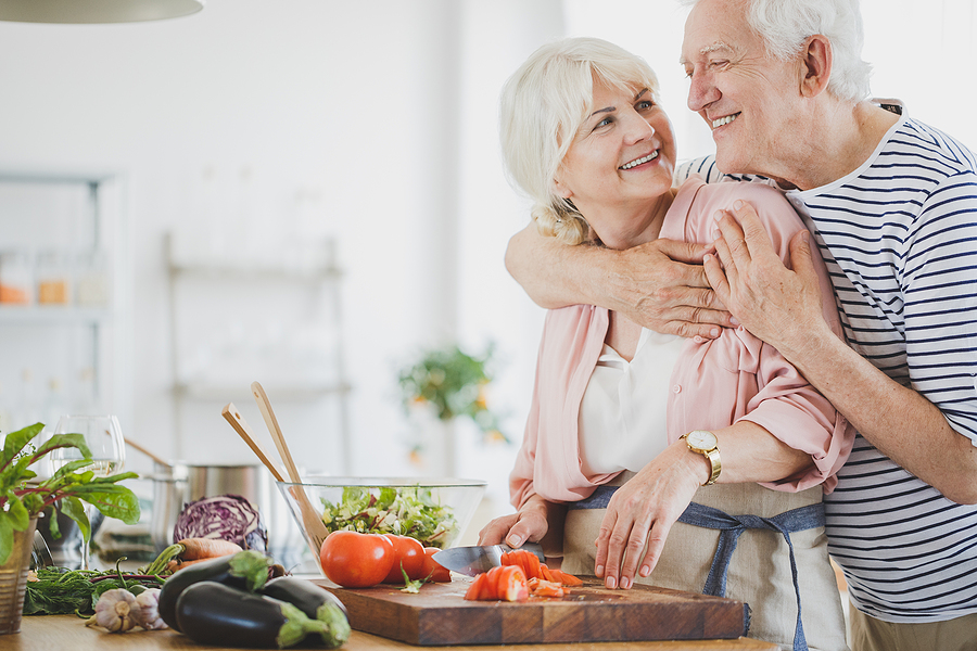 A senior couple makes dinner together.