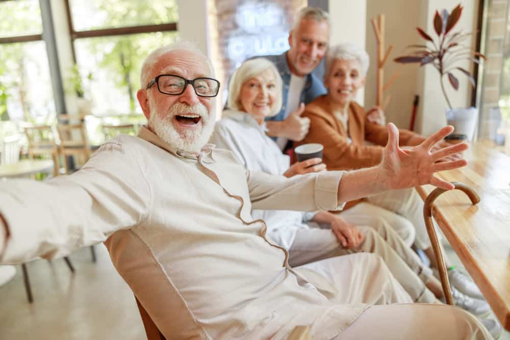 A group of joyous seniors sitting down for coffee