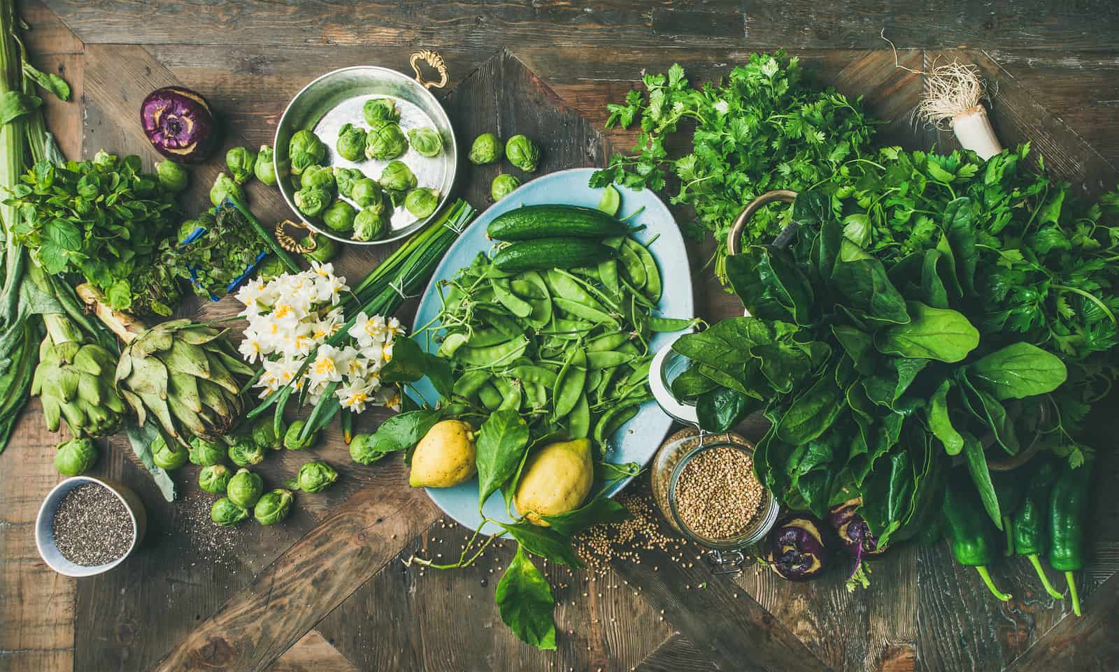 An array of vegetables and spices collected on a wooden table for a spring meal