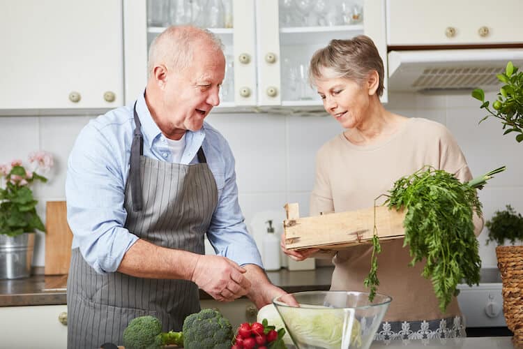 Senior couple cooking a meal during National Nutrition Month.