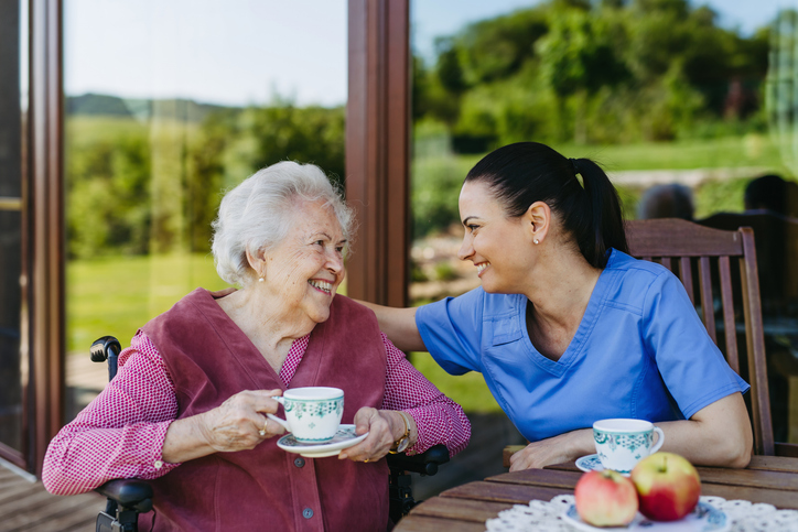 Senior having a cup of tea with caregiver