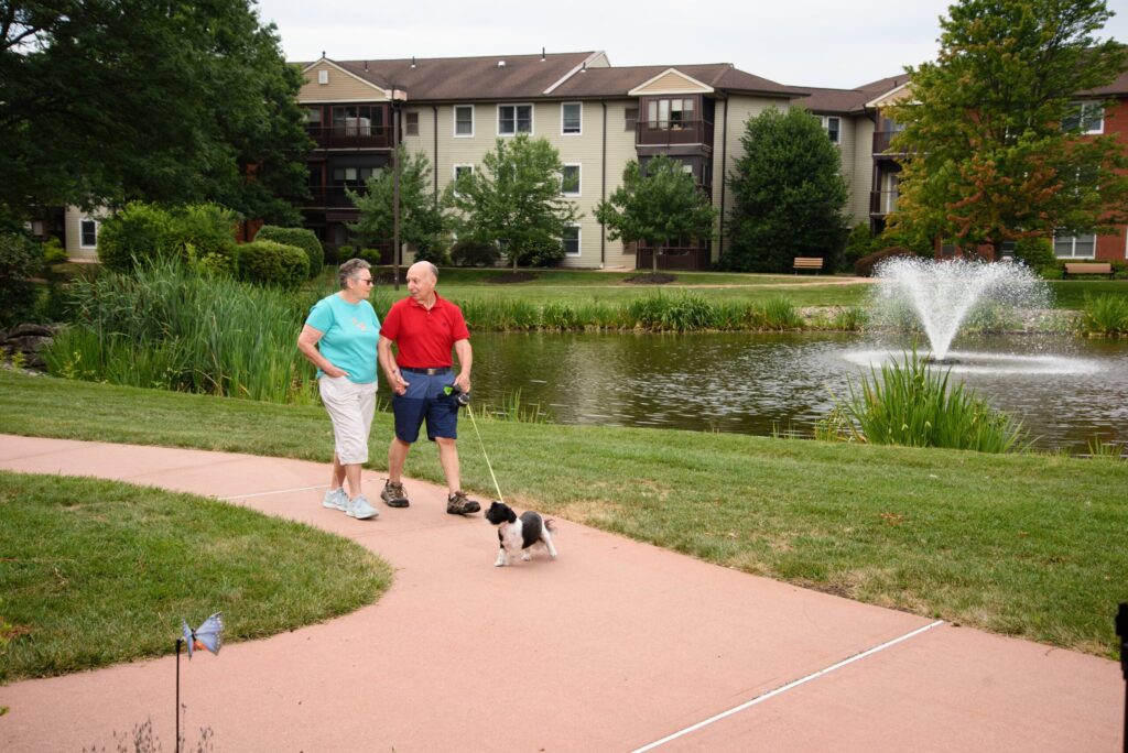 Seniors walking dog on sidewalk