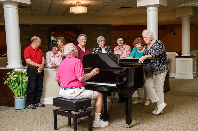 Seniors listening to friend playing piano