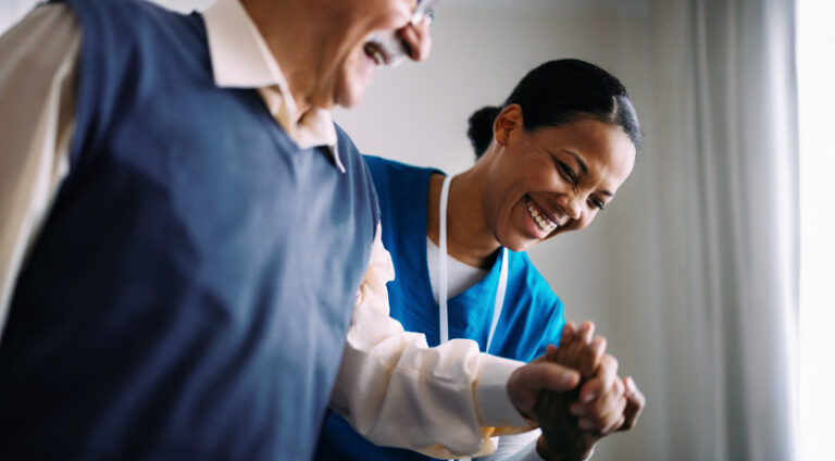 Senior being helped up by caregiver