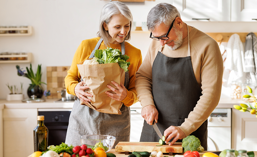 A senior couple prepares a meal together