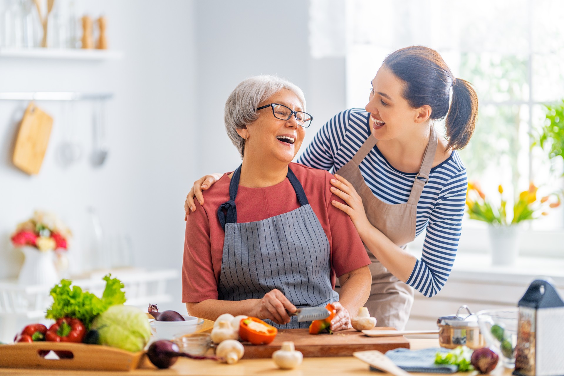 Happy senior woman and her daughter prepping a healthy meal together