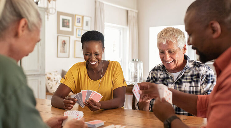 Group of friends laughing and playing a card game