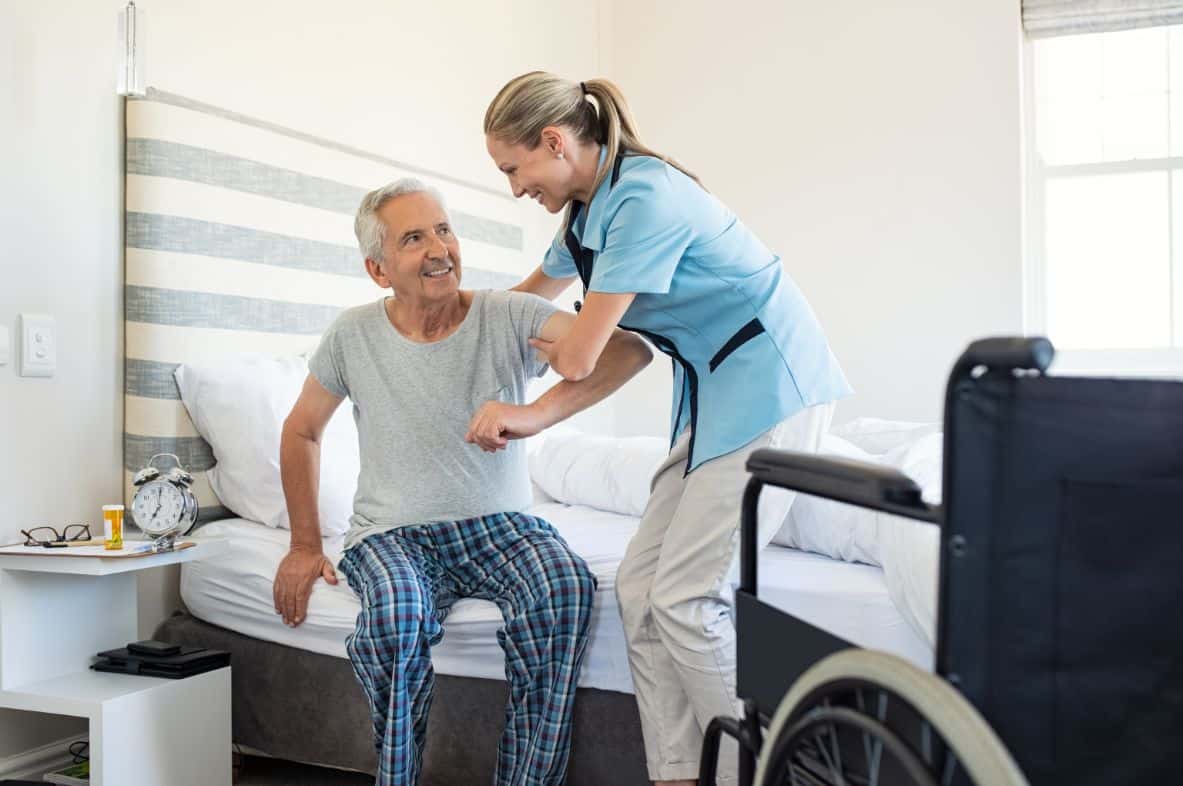 Senior man receiving help from a healthcare team member at a senior living community.
