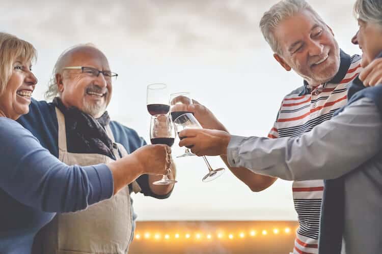 Senior friends enjoying a glass of wine at a continuing care retirement community.