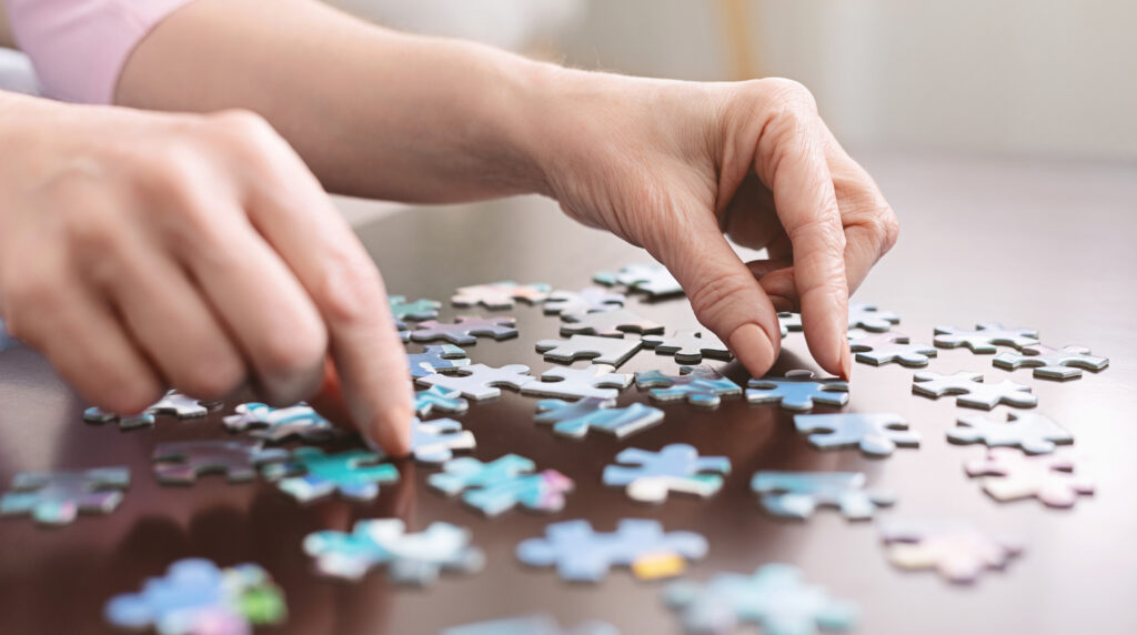 Senior completing puzzle hand shot