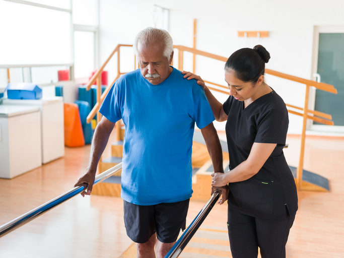 Senior at pysical threapy with caregiver