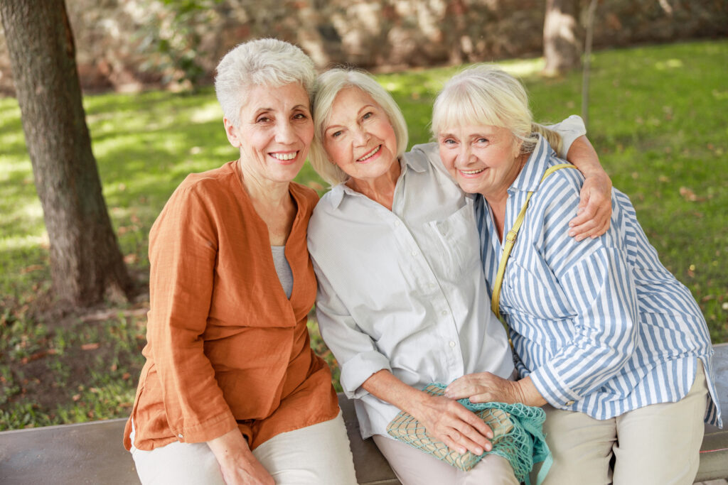 Senior female friends sit on site to take a photo