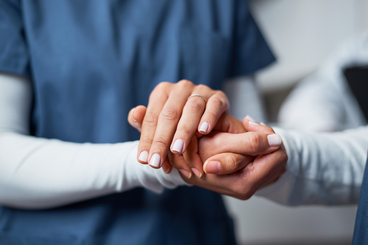 Caregiver holding hands with senior
