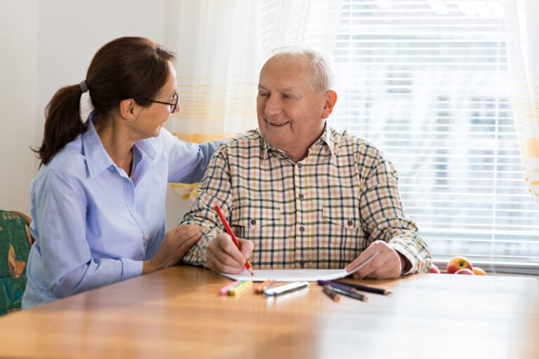 Senior drawing picture with caregiver